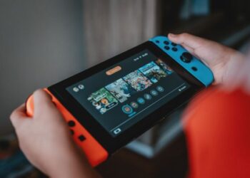 person holding black and orange nintendo switch - Nintendo Switch!, tags: de shiver - unsplash