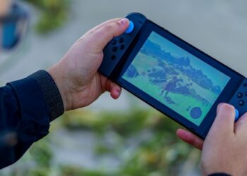 a person is playing a video game on a cell phone - Nintendo switch player , tags: la 2 révélation - unsplash